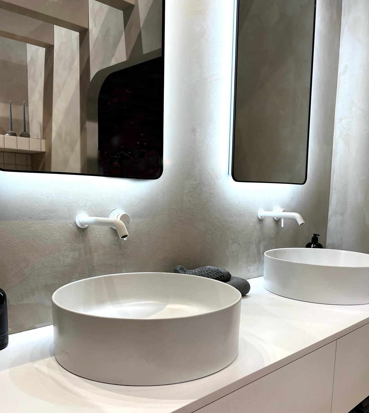 Double vanity with microcement walls and backlit arched LED mirrors, Hamilton Ontario