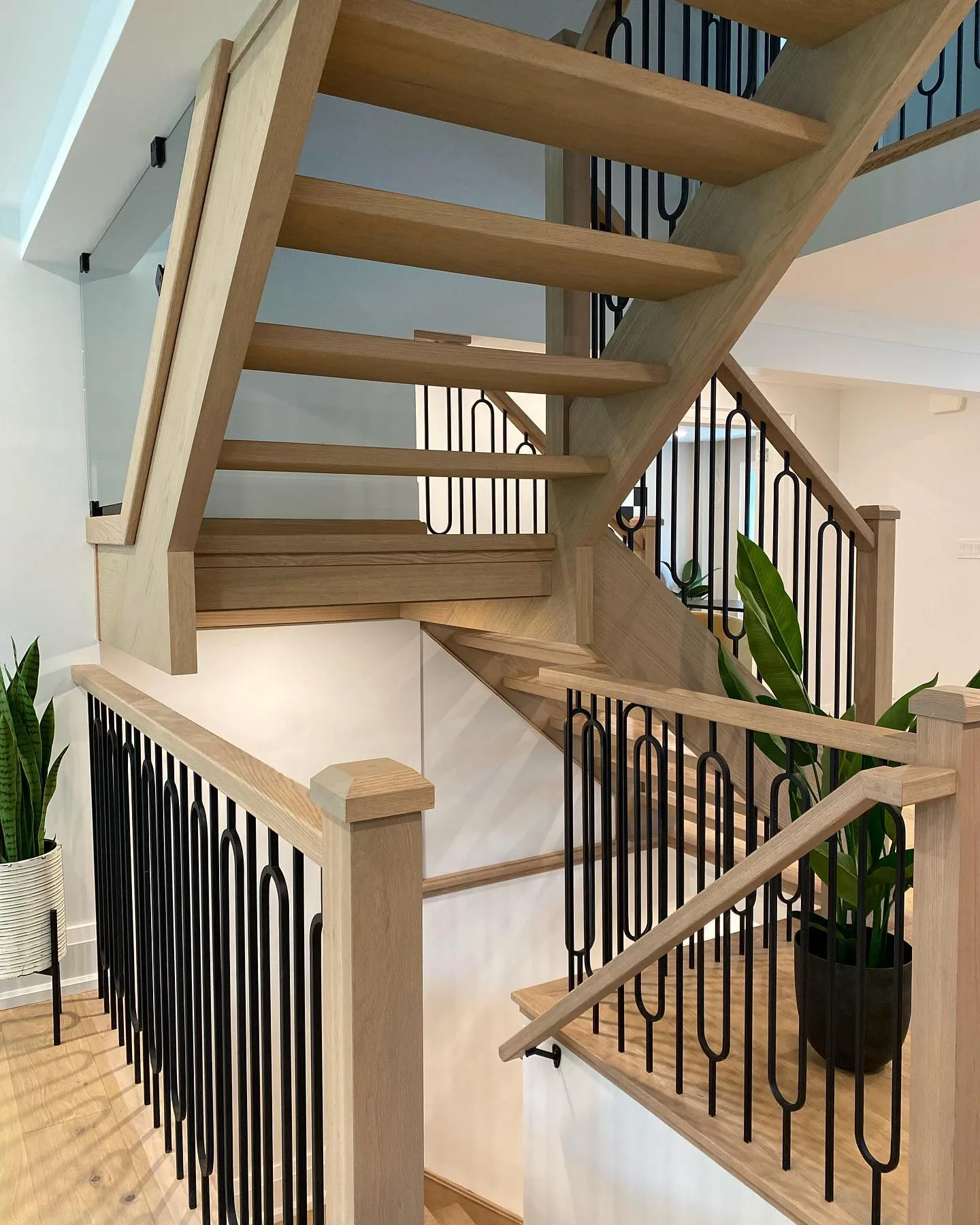 Open-riser white oak staircase with black iron arch balusters, Hamilton Ontario